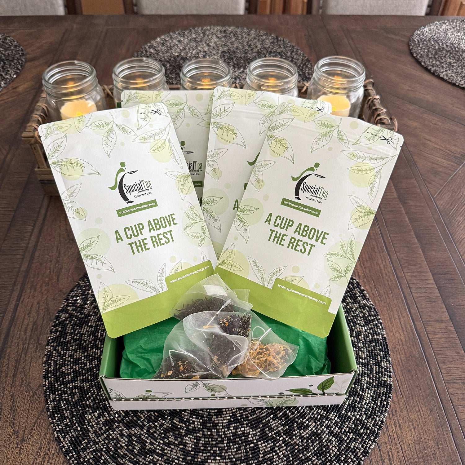 Box of tea bags with packaging labeled 'A Cup Above the Rest' on a wooden table.