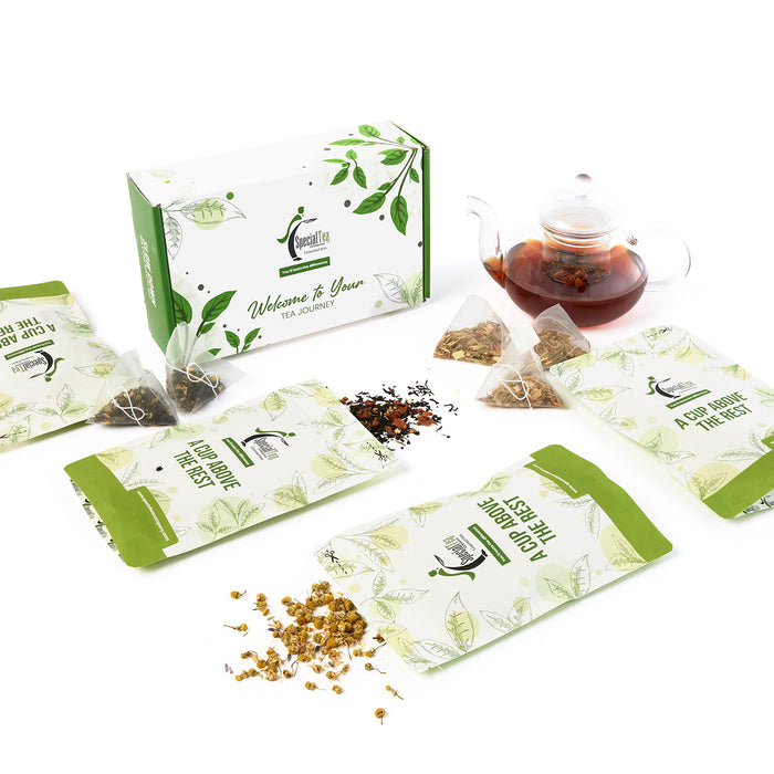 Tea bags with green packaging and a glass teapot filled with tea on a white background